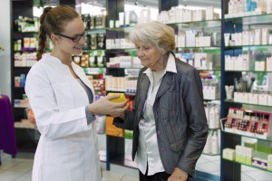 Pharmacist advising medication to senior patient.
